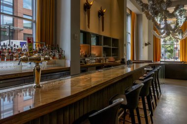 Durham, NC - ABD - 3 Mayıs 2025 Müze Oteli 'ndeki Muhasebe Salonu modern zarafeti sanatsal bir yetenekle harmanlıyor, gösterişli bir bar, heykeltraş ışığı ve canlı bir dekorla..