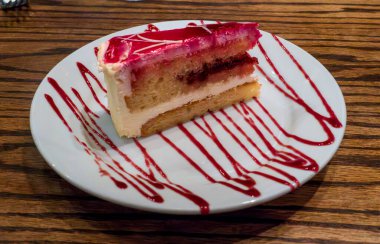 Bir dilim nemli Limoncello pastası canlı ahududu sosuyla sulandırılır, ferahlatıcı, zarif bir tatlı deneyimi için lezzetli narenciye ve tatlı böğürtlen aroması harmanlanır..