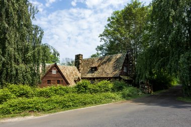 Millbrook, New York - ABD 13 Haziran 2025 Kırsal bir ahşap ve taş kapılar Innisfree Bahçesi 'nin girişi, yapraklı ağaçlar ve gür çalılarla çevrili ve ziyaretçileri ağırlayan.