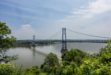 Poughkeepsie, New York - ABD - 13 Haziran 2025 Franklin D. Roosevelt Mid-Hudson Köprüsü Hudson Vadisi 'ni dramatik manzaralarla birleştiren zarif bir asma köprü olan Poughkeepsie' deki Hudson Nehri boyunca uzanır..