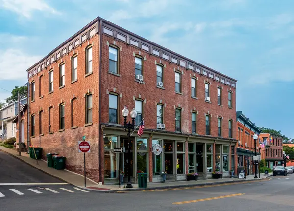 Beacon, New York - ABD 13 Haziran 2025 Beacon, New York 'taki ana caddede eski usul üç katlı tuğla bir bina altında büyüleyici mağazalar ve yukarıda klasik pencereler, küçük kasaba mirasını yansıtıyor..