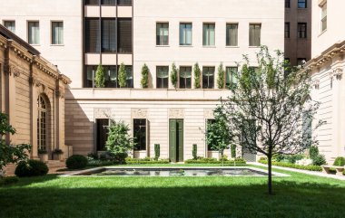 New York, New York - ABD - 6 Haziran 2025 Frick Collection 'daki bahçe, manikürlü çimenler, yontulmuş ağaçlar, merkezi bir yansıtma havuzu ve klasik mimariyle huzurlu bir kaçış sunuyor..