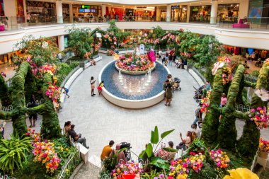 Doğu Rutherford, NJ - ABD - 26 Haziran 2025 Canlı çiçekler, çeşmeler ve çalı heykeller ile gür bir kapalı bahçe Amerikan Rüya Merkezi 'nin hareketli dükkanları arasında sakin bir kaçış yaratır.