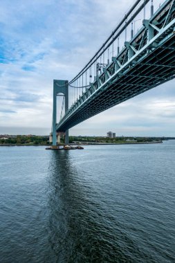 New York, New York, ABD - Sep 27, 2025 Verrazzano-Narrows Köprüsü bulutlu mavi gökyüzünün altında zarif bir şekilde Brooklyn ve Staten Island 'ı süpürge çelik kemerlerle birbirine bağlıyor.