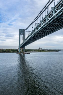 New York, New York, ABD - Sep 27, 2025 Verrazzano-Narrows Köprüsü bulutlu mavi gökyüzünün altında zarif bir şekilde Brooklyn ve Staten Island 'ı süpürge çelik kemerlerle birbirine bağlıyor.