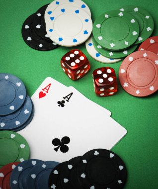 Yukarıdaki yeşil poker masasında kumar, zar ve poker fişleri