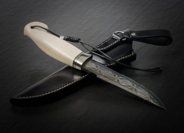 Kılıflı, eski bir av bıçağı. Kemik sapı, beyaz üzerine.. 