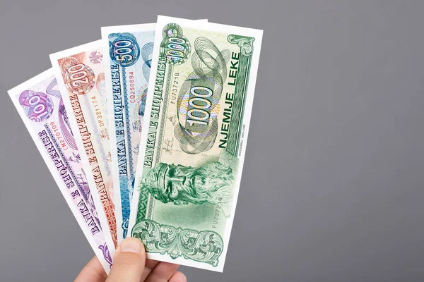 stock image Old Albanian money - lek in the hand on a gray background