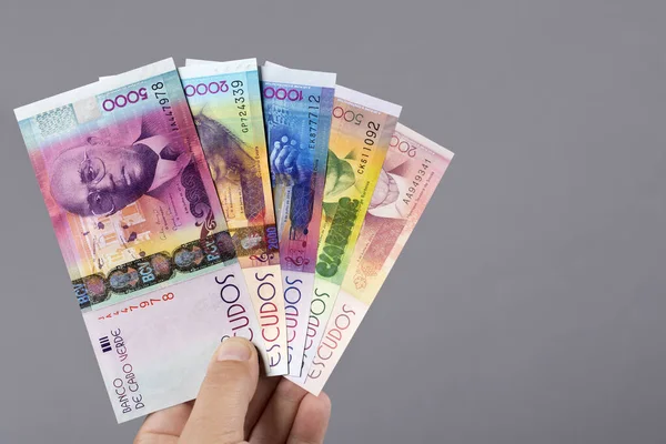 Cape Verdean parası - Gri bir arka planda elinde escudo