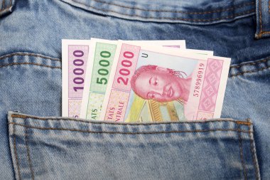 Old Central African CFA money - franc  in the pocket of blue jeans clipart