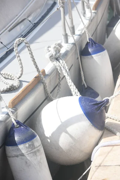 Korunmak amacıyla tekne ile rıhtım arasında asılı duran beyaz çamurlukların ayrıntıları. Deniz çamurlukları