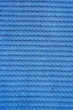 Vertical full-frame background image with a blue fabric with decorative embossing