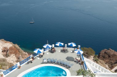 Kalderanın ve Santorini Denizi 'nin sersemletici panoramik manzarası havuzu, güneşliği ve oturma yerleri olan bir terastan. Etrafı volkanik kayalıklarla ve bar hizmetiyle çevrili tatilleri rahatlatmak için ideal..