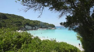 Yunanistan 'ın AntiPaxos adasındaki plajın panoramik videosu Turkuaz denizi yeşil tepeler arasında turistlerin sükunetin tadını çıkardığı güzel bir plaj. Rahatlamak ve doğa için mükemmel bir yer..