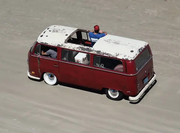 Retro Mini Van Crociera Sabbia Dura Con Uomo Guardare Gli Foto Stock