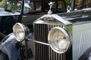1933 'ten kalma Rolls Royce HP, 46' da Uçan Kadın maskotu teşhir edildi. 2023 'te Baden-Baden, Almanya' da Uluslararası Oldtimer-Toplantısı. Arka planda, siyah bir Rolls Royce HP 1934 'ten 20 / 25..