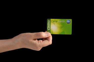 Fransız bir süpermarketten geri ödeme kartı tutan bir el. Siyah bir arkaplanda izole edilmiş.