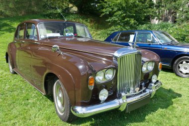 Bentley S3 Saloon, 1964 'ten kalma lüks bir araba 47' de ortaya çıktı. 2024 'te Baden-Baden' de Uluslararası Oldtimer Toplantısı. Almanya. Arka planda 1995 yılından kalma mavi bir Rolls-Royce Uçan Mahmuz.