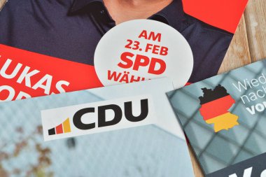 Alman federal seçimleri 2025 CDU ve SPD siyasi partilerinin kampanya broşürleri masada. Seçim 23 Şubat 2025 'te yapıldı..