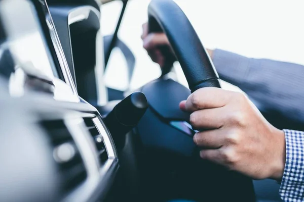 stock image Male hands holding steering wheel of a car
