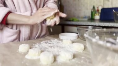 Mutfak masasında süzme peynirli krep yapan kadın eller. Masada lezzetli bir kahvaltı hazırlayan genç bayanın kolları. Ev mutfağında cheesecake yapma süreci. Sağlıklı gıda konsepti..
