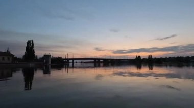 Kherson kasabasındaki sokakları su basmıştı. Arka planda güzel bir günbatımı vardı. Novaya Kakhovka kentindeki Dnipro nehrinde baraj patlaması. Kakhovka Hidroelektrik Santralinin patlamasının sonuçları