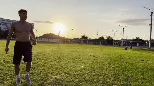 两个运动员在场上互相传递球的时候 表现得很有技巧 日落时 年轻人在体育场踢足球 职业足球运动员在草地上训练 自由式足球 — 图库视频影像