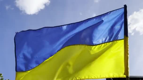 在阳光灿烂的日子里 乌克兰蓝色和黄色的象征飘扬 旗杆上的乌克兰国旗迎风飘扬 和平与支持反对俄国侵略的概念 抵抗入侵 — 图库视频影像