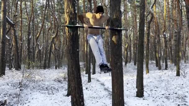 强壮而强壮的男子在冬季森林的横梁上做运动 年轻的运动员在美丽的大自然中挣扎着 田径选手在室外训练体育和积极生活方式的概念 — 图库视频影像