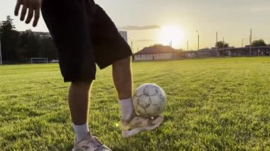 Sahada birbirlerine pas verirken iki sporcu topla numara yapıyor. Gençler gün batımında stadyumda futbol oynuyorlar. Meadow 'da profesyonel futbolcu eğitimi. Serbest stil futbol.