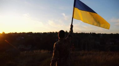 Ukrayna ordusunun genç askeri, Rusya 'nın işgal ettiği özgür topraklara mavi-sarı bayrak dikti. Erkek ordu, gün batımında Rus saldırısına karşı zafer onuruna Ukrayna bayrağını kaldırdı..