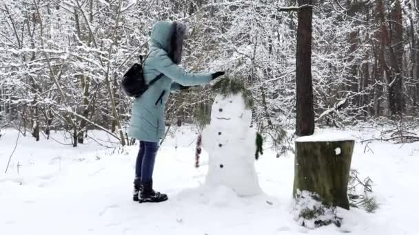 Молода Дівчина Побудувала Сніговика Зимовому Лісі Щаслива Жінка Прикрашає Снігового — стокове відео
