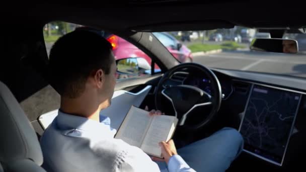 Pria Pebisnis Membaca Buku Selama Mengendarai Kendaraan Listrik Dengan Autopilot — Stok Video