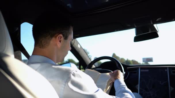 Pria Pebisnis Membaca Buku Selama Mengendarai Kendaraan Listrik Dengan Autopilot — Stok Video