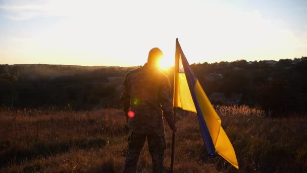 Ουκρανός Στρατιωτικός Στέκεται Εθνικό Λάβαρο Στην Εξοχή Ηλιοβασίλεμα Άντρας Στρατιώτης — Αρχείο Βίντεο