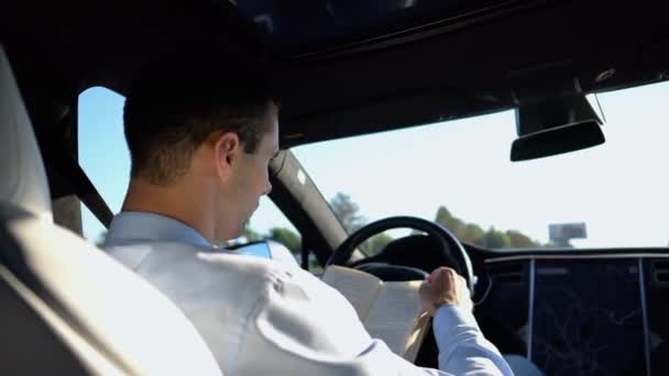 Mężczyzna Biznesmen Czytający Książkę Podczas Jazdy Pojeździe Elektrycznym Autopilotem Drodze — Wideo stockowe