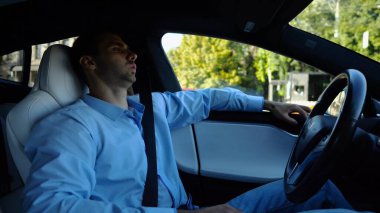 Kentsel yolda kendi kendini kullanan bir erkek işadamı deneyimi. Şehirdeki otomatik pilotla elektrikli otomobilde dinlenen kendine güvenen bir iş adamı. Yavaş çekim