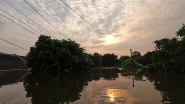 Kherson kasabasındaki sokakları su basmıştı. Arka planda güzel bir günbatımı vardı. Novaya Kakhovka kentindeki Dnipro nehrinde baraj patlaması. Kakhovka Hidroelektrik Santralinin patlamasının sonuçları.