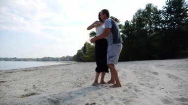 El ele tutuşup sahilde yürüyen bir çift. Adam kadını havaya uçurup kıyı şeridinde geri dönüyor. Mutlu çift yaz tatilinde deniz kıyısında birlikte eğleniyor. Aşk kavramı.