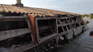 Kakhovka Hidroelektrik Santrali 'nin patlamasından sonra korkmuş kediyi evin çatısından kurtarmaya çalışan gönüllü. Kherson kasabasındaki Dnipro nehrinde barajın patlaması sonucu.