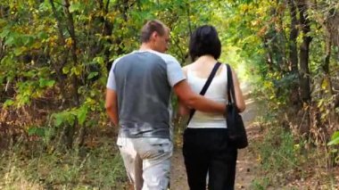 Yaz ormanı yolunda yürüyen bir çift. Vahşi Orman 'da gezen mutlu bir çift. Sevgililer doğada birlikte vakit geçirirler. Aşk ve mutluluk kavramı. Yavaş çekim