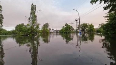 Kherson kasabasındaki sokakları su basmıştı. Arka planda güzel bir günbatımı vardı. Novaya Kakhovka kentindeki Dnipro nehrinde baraj patlaması. Kakhovka Hidroelektrik Santralinin patlamasının sonuçları.