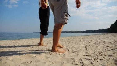 El ele tutuşup sahilde yürüyen bir çift. Güneşli bir günde deniz kıyısına giden mutlu bir çift. Sevgililer tatil köyünde birlikte vakit geçirirler. Tatil ya da tatil kavramı. Yavaş çekim