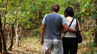 Yaz ormanı yolunda yürüyen bir çift. Vahşi Orman 'da gezen mutlu bir çift. Sevgililer doğada birlikte vakit geçirirler. Aşk ve mutluluk kavramı. Yavaş çekim