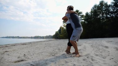 El ele tutuşup sahilde yürüyen bir çift. Adam kadını havaya uçurup kıyı şeridinde geri dönüyor. Mutlu çift yaz tatilinde deniz kıyısında birlikte eğleniyor. Aşk kavramı.