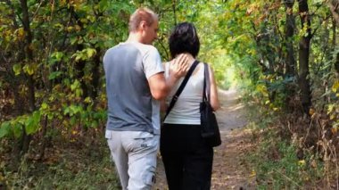 Yaz ormanı yolunda yürüyen bir çift. Vahşi Orman 'da gezen mutlu bir çift. Sevgililer doğada birlikte vakit geçirirler. Aşk ve mutluluk kavramı. Yavaş çekim