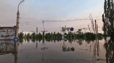 Kherson kasabasındaki sokakları su basmıştı. Arka planda güzel bir günbatımı vardı. Novaya Kakhovka kentindeki Dnipro nehrinde baraj patlaması. Kakhovka Hidroelektrik Santralinin patlamasının sonuçları.