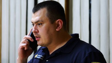 Erkek itfaiyeci şefi, itfaiye istasyonunda astıyla ciddi bir telefon görüşmesi yapıyor. İtfaiyeci itfaiyede cep telefonuyla konuşuyor. Kahramanlık kavramı..