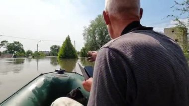Kakhovka Hidroelektrik Santrali 'nin patlamasından sonra, gönüllüler sıska köpekle birlikte tekneye biniyor. Kherson kasabasındaki Dnipro nehrinde barajın patlamasının sonuçları. Yavaş çekim