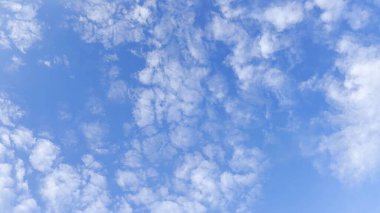 Yaz güneşli bir günde mavi gökyüzünde beyaz kabarık bulutların arkasında kamera hareket eder. Güzel bir doğa geçmişi var. Yavaşla.